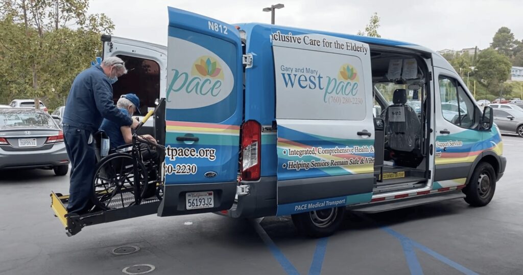West PACE team member helping a man in a wheelchair into a support vehicle