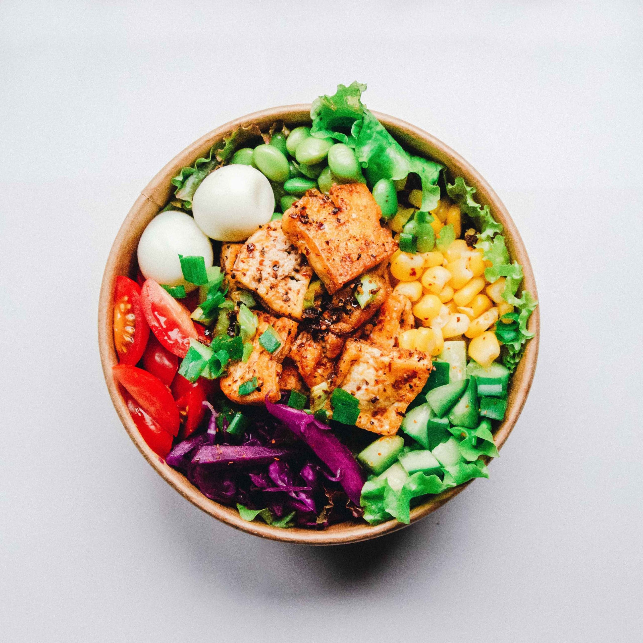 Healthy salad bowl topped with grilled chicken
