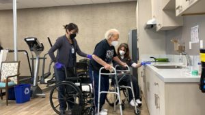 A picture of Ally helping a senior do occupational therapy. 