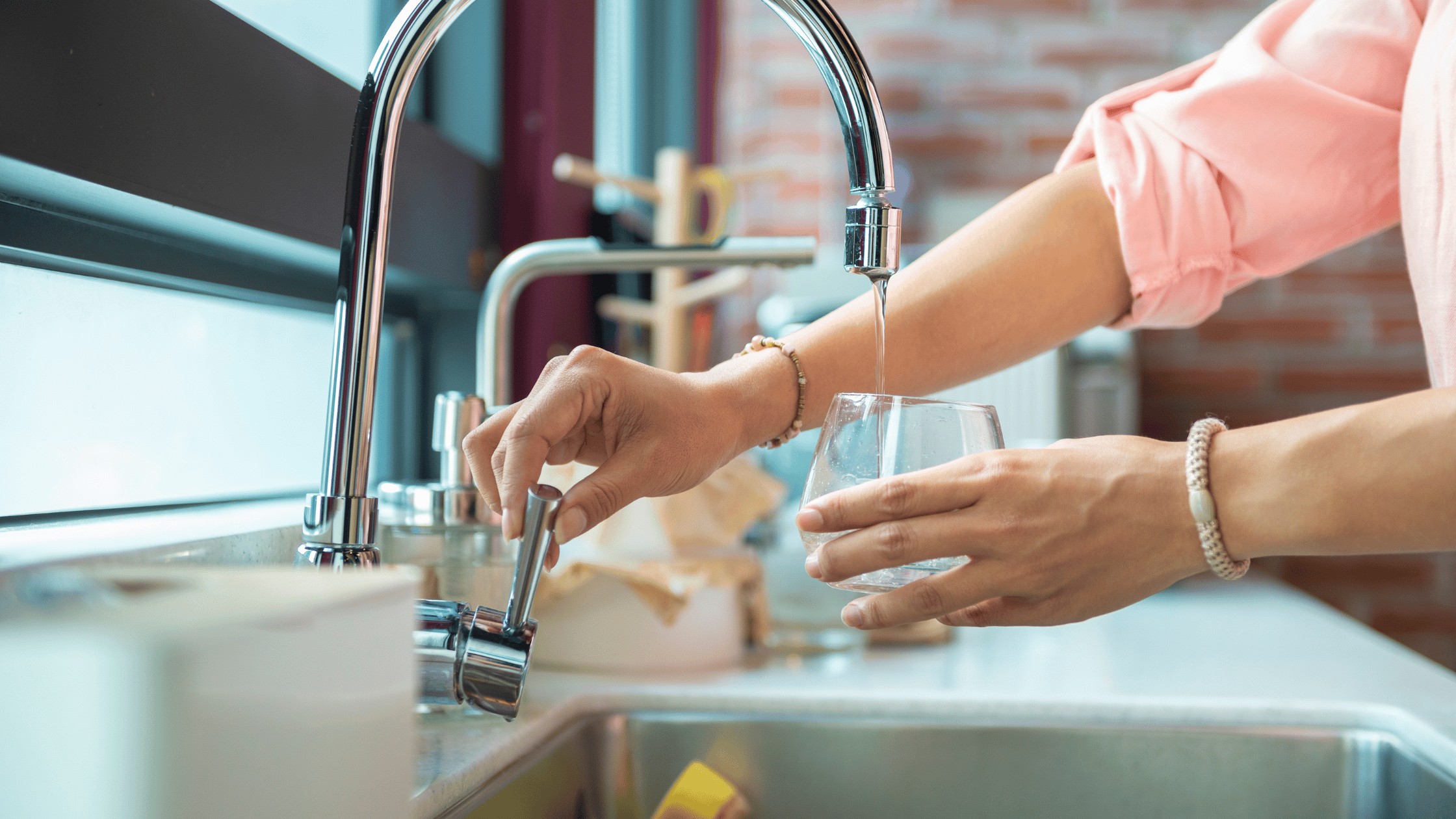 a women pouring a glass of water to stay hydrated. 