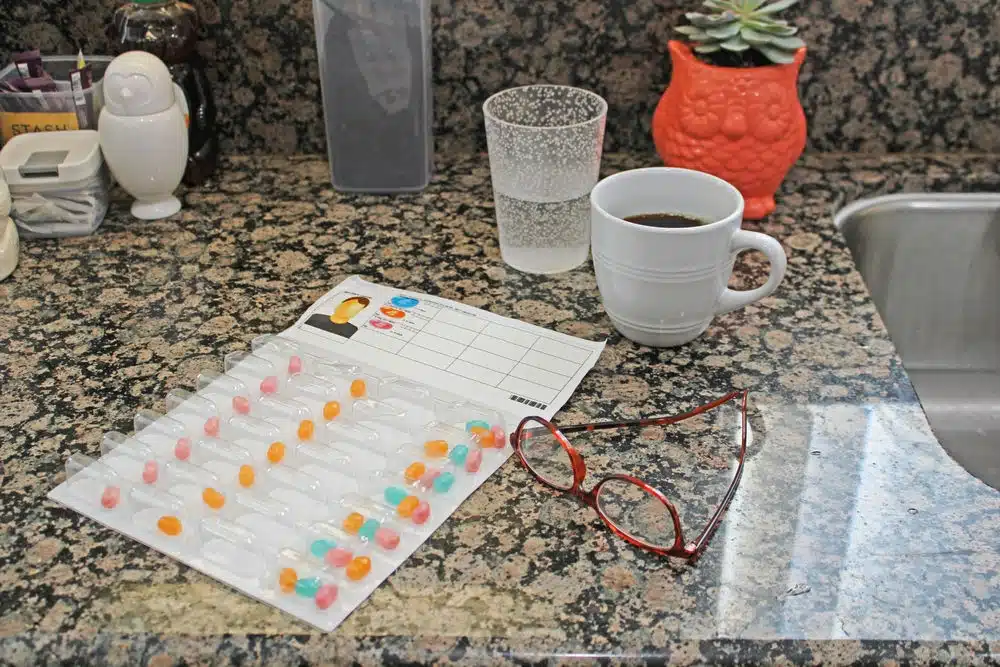 Hand putting tablets in automatic medication dispenser